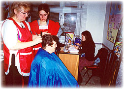 Hairdresser-volunteer is serving clients in Hesed